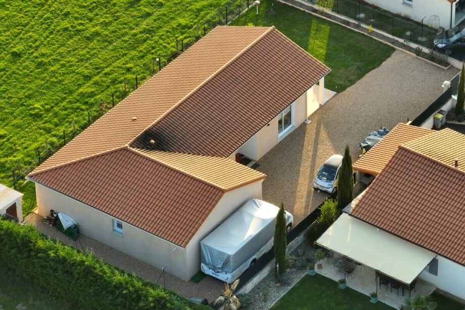 Widok z lotu ptaka na osiedle, gdzie domy stalowe posiadają czerwone dachówki.